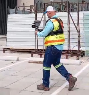 Técnico realizando escaneo LiDAR SLAM portátil en obra de construcción